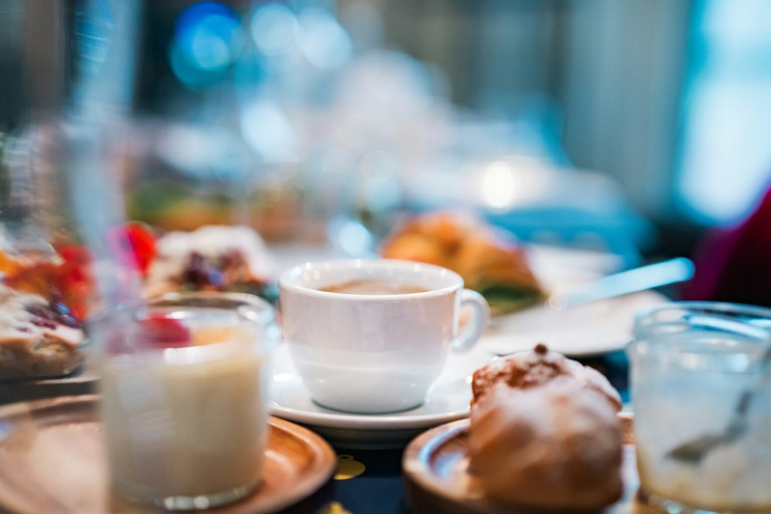 Frühstückstisch mit Kaffee, Gebäck und frischen Zutaten